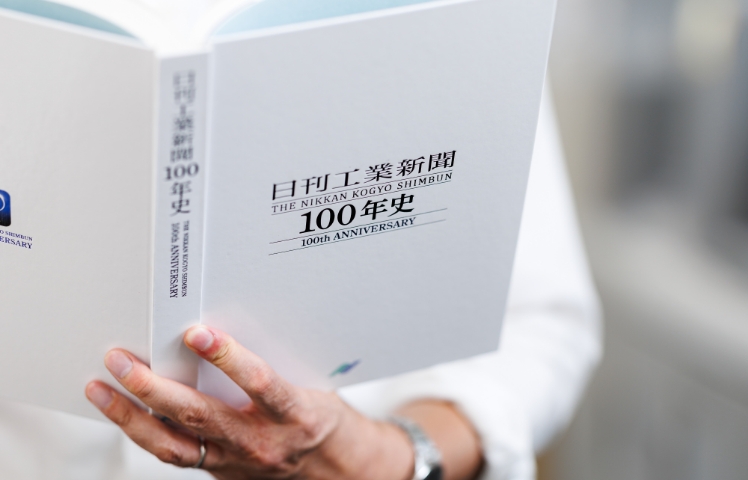 社史を手に取る様子