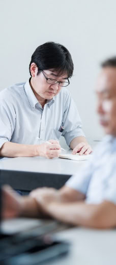 書類を手に打ち合わせをするスタッフ