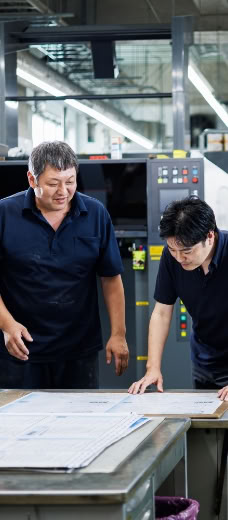印刷内容を確認する二人のスタッフ